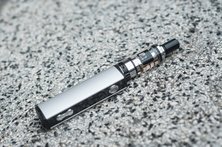 Closeup of grey electronic cigarette on stoned backgroundの写真素材