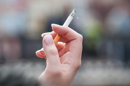closeup of woman with cigarette in outdoor の写真素材