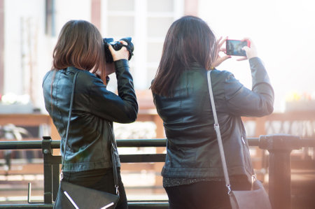 Strasbourg - France - 20 April 2019 - Portrait of women taking a picture in the street of Strasbourg on back viewのeditorial素材