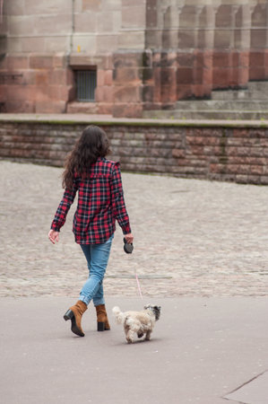 Mulhouse - France - 25 April 2019 - portrait of girl walking with dog in the street on back viewのeditorial素材