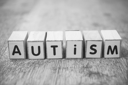 Closeup of word on wooden cube on wooden desk background concept - Autismの写真素材