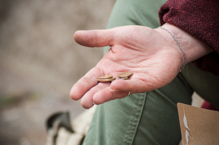 closeup of euros coins in hand of poor woman