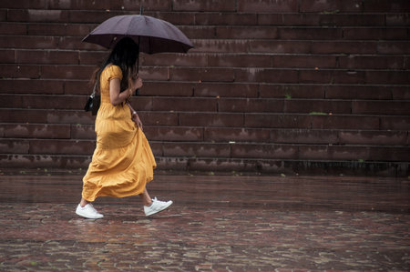 Mulhouse - France - 28 May 2019 - portrait of woman wearing with a yellow dress walking with...