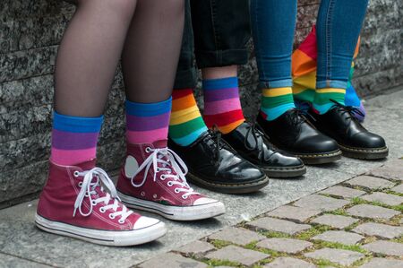 Closeup of rainbow socks on lesbian girl sitting on bench  in the street