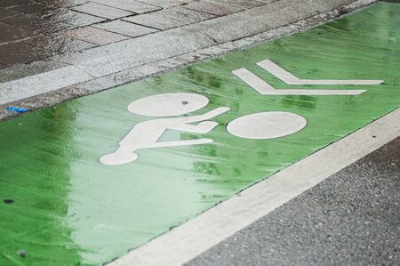Closeup of wet bike path in the street by rainy dayの写真素材