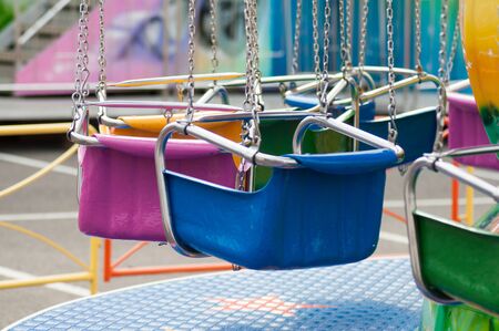 closeup of carrousel chairs in attraction park