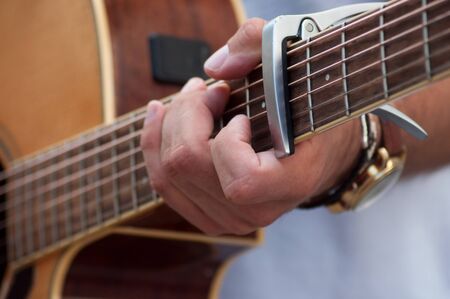closeup of hand of musician on folk guitar in the street