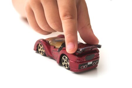 Closeup of hand of kid playng with miniature carの写真素材