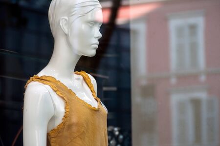 closeup of yellow summer dress on mannequin  in women fashion store showroom
