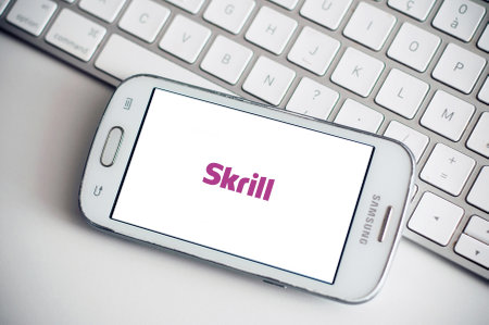 Mulhouse - France - 3 September 2019 - Closeup of Skrill logo on smartphone screen from Samsung brand on white keyboard backgroundのeditorial素材