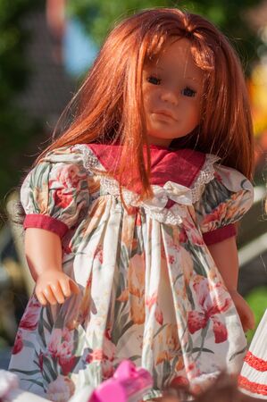 Closeup of vintage dolls with red hairs and beautiful dress at flea market in the streetの写真素材