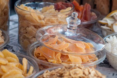 Closeup of dried fruits assortment in glass containers at the marketの写真素材