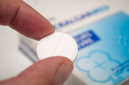 Mulhouse - France - 18 September 2019 - Closeup of Efferalgan pill in hand on cardboard box on...