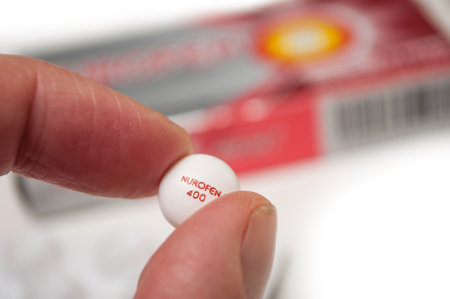 Mulhouse - France - 18 September 2019 - Closeup of pill of Nurofen in hand on nurofen cardboard box backgroundのeditorial素材