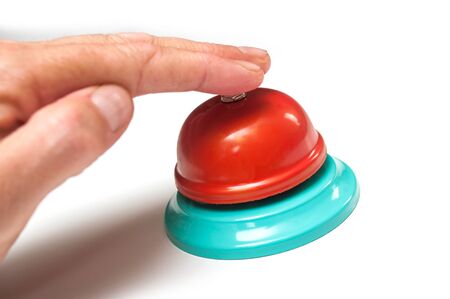 Closeup of hand of man on vintage hotel bell on white backgroundの写真素材