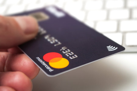 Mulhouse - France - 22 November 2019 -  Closeup of Skril mastercard   in hand for e commerce on white keyboard backgroundのeditorial素材
