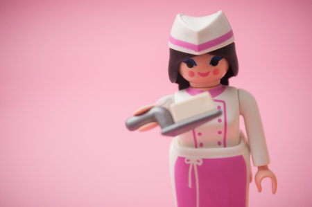 Mulhouse - France - 26 November 2019 - Closeup of PLaymobil figurine with pastry costume on pink backgroundのeditorial素材