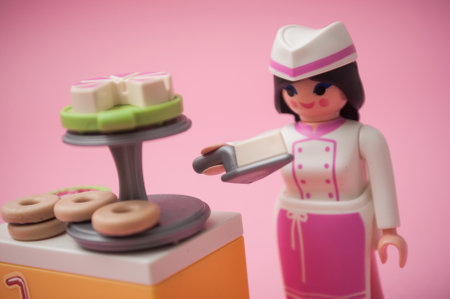 Mulhouse - France - 26 November 2019 - Closeup of PLaymobil figurine with pastry costume on pink backgroundのeditorial素材