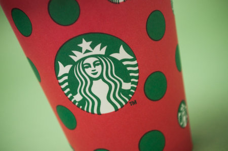 Mulhouse - france - 28 November 2019 - Closeup of merry christmas take away cup in outdoor from Starbucks brand on green background, Starbucks is the famous chain of fast foodのeditorial素材