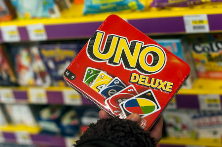 Mulhouse - France - 7 December 2019 - Closeup of Uno game cards in hand of woman in a toy store...