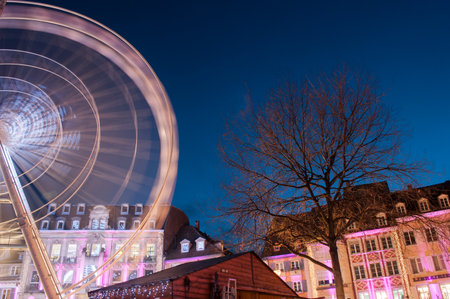 Mulhouse - France - 16 December 2019 - view of illuminations of the christmas market on the main place with big wheel on backgroundのeditorial素材