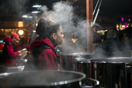 Mulhouse - France - 27 December 2019 -  portrait of woman giving mulled wine at the christmas market
