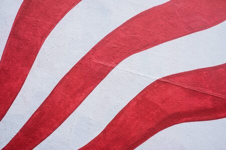 closeup of red and white lines painting on the wall textureの写真素材