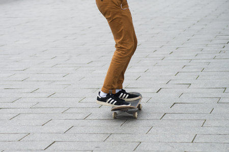 Mulhouse - France - 31 January 2020 - Closeup of skater legs wearing black sneakers by Adidas rolling on skate board in the streetのeditorial素材