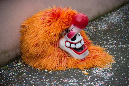 riedisheim - France - 8 February 2020 - Closeup of carnival mask with orange wig posing on the floor before the carnivalのeditorial素材