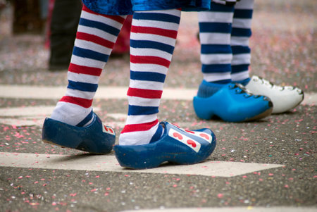 Closeup of legs of people parading in the street with blue wooden shoes and striped socksのeditorial素材