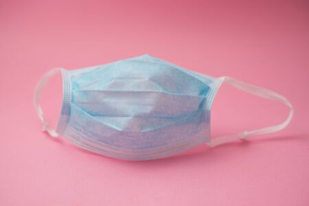 Closeup of medical mask on pink background to protect against the corona virusの写真素材