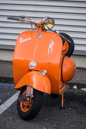 Mulhouse - France - 8 Mars 2020 - front view of orange color vespa parked in the streetのeditorial素材