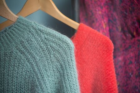 Closeup of woolen pullover on hangers in a fashion sotre showroomの写真素材