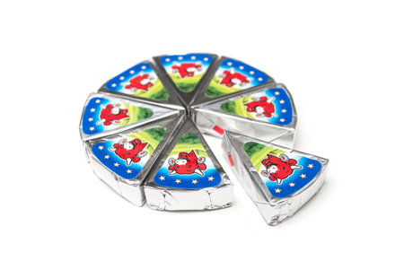 Mulhouse - France - 25 April 2020 - Closeup of piece of french cheese La vache qui rit, traduction in english : the laughing cow on white backgroundのeditorial素材