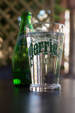 Mulhouse - France - July 6, 2020 - Closeup of Perrier glass of carbonated mineral water on terrace restaurantのeditorial素材
