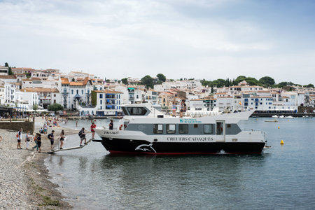 Cadaques - Spain - 10 July 2020 - view of tourists boarding in boat in the harbor on seascape backgroundのeditorial素材