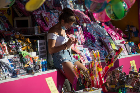 Mulhouse - France - 5 August 2020 - Portrait of girl wearing a blue jeans short waiting in stand at the fun fairのeditorial素材