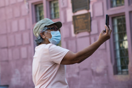 Mulhouse - France - 21 August 2020 - Portrait on tourist taking a photo with her smartphone during the covid-19 pandemicのeditorial素材