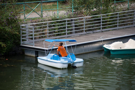 Mulhouse - France - 21 August 2020 - Portrait on back view of man employee on rental pedalo in the river in the cityのeditorial素材