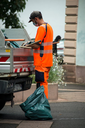 Mulhouse - France - 22 August 2020 - Municipal employee wearing orange vest working in the streetのeditorial素材