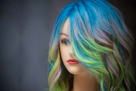 Closeup of head of mannequin with colorful hairs in a hairdresser showroom