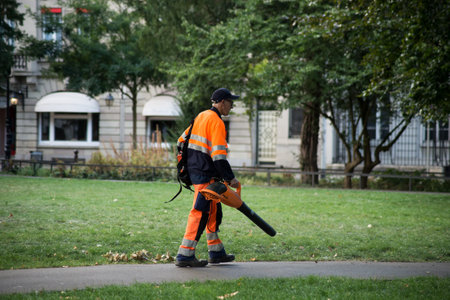 Mulhouse - France - 23 Auguqt 2020 - Portrait of municipal gardener using a using leaf blower for cleaning of the way in a public gardenのeditorial素材