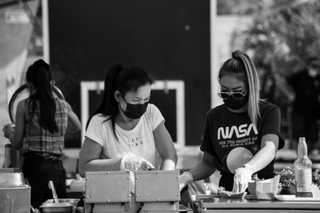 Mulhouse - France - 13 September 2020 - Portrait of asian women preparing food wearing a medical mask during the covid-19 pandemicのeditorial素材