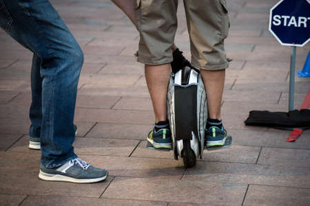 Closeup of legs of man on an electric mono cycle in the street