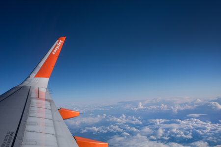 Lisbon - Portugal - 2 October 2020 - View of easy jet wing of plane on blue cloudy sky backgroundのeditorial素材