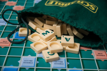 Mulhouse - France - 16 November 2020 - Closeup of plastic letters of Scrabble game fallen from bag on boardgameのeditorial素材