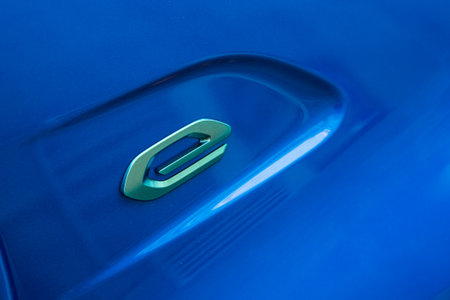 Mulhouse - France - 17 November 2020 - Closeup of E sign on blue electric Peugeot 208 parked in the...