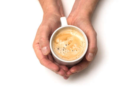 Closeup of hands of man with a mug of coffee on white backgroundの写真素材