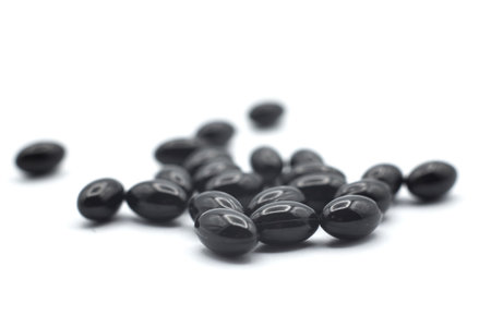 Closeup of black pills of coal on white backgroundの写真素材