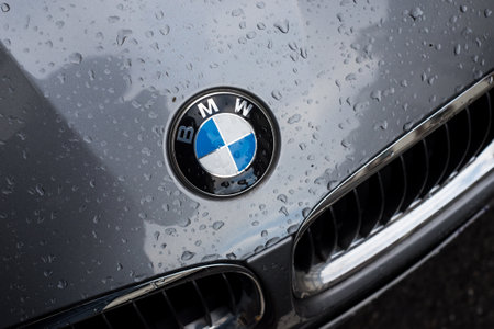 Mulhouse - France - 13 December 2020 - Closeup of rain drops on the logo of grey Bmw car parked in the streetのeditorial素材